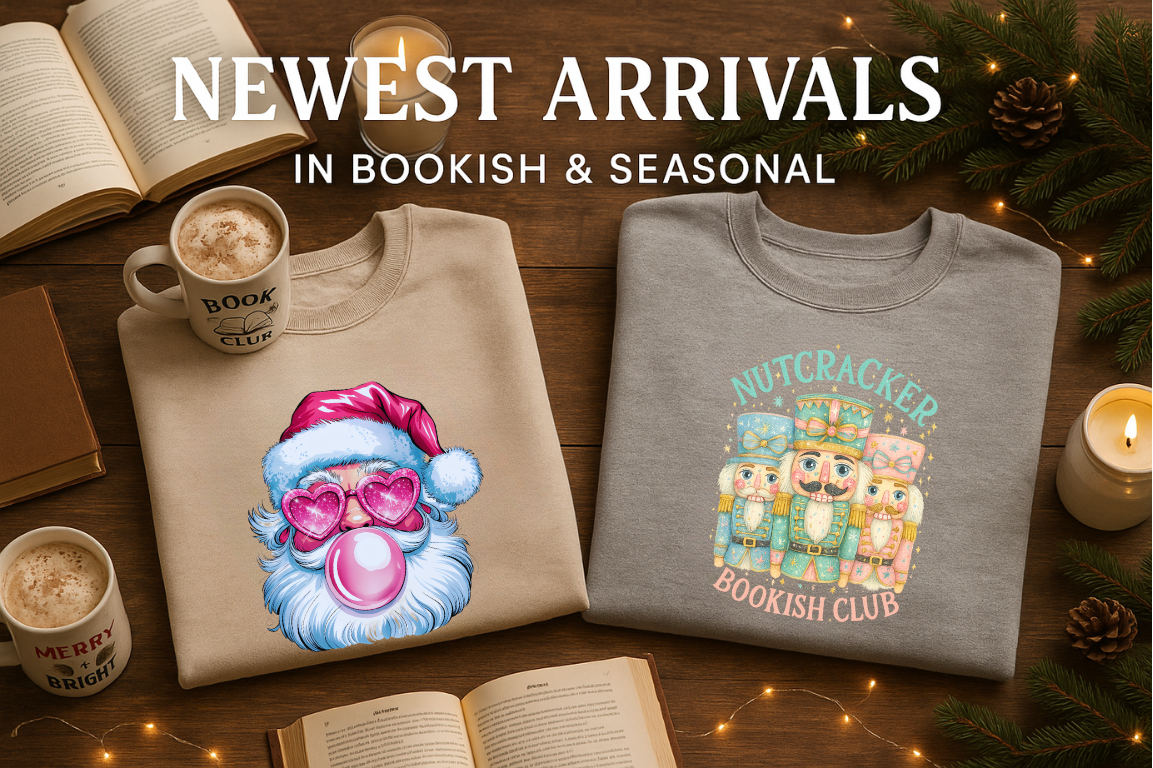 Two sweaters with festive designs on a wooden surface with books and coffee cups.